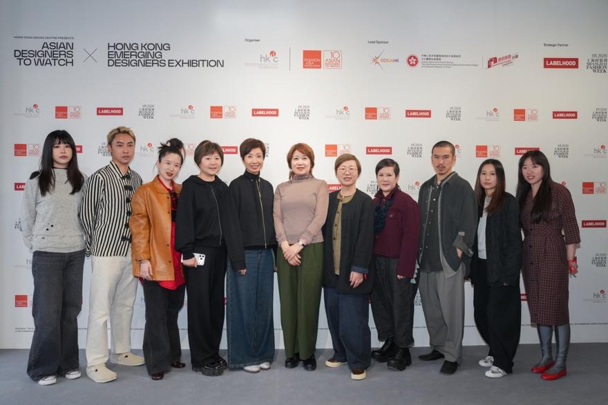 A group of people standing in front of a wallAI-generated content may be incorrect.